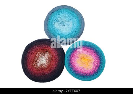 The image features three skeins of multicolored yarn in gradient patterns arranged on a white background. Each skein showcases a unique blend of color Stock Photo