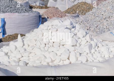 White marble pebbles are sold in construction market. Close up of materials pile. Building white materials for decoration and construction. Stock Photo