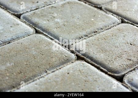 Background from a gray sidewalk path. Close-up of concrete paving slab bricks. Stock Photo