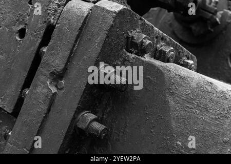 Massive parts of vintage black industrial machine, close up black and white photo with selective focus, abstract heavy industry background Stock Photo