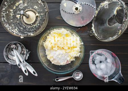 Making Pie Crust with Grated Frozen Butter: Unsalted butter shredded with a food processor in a mixing bowl with flour, sugar, and salt Stock Photo