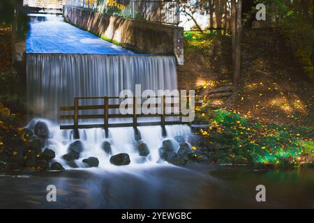 Long exposura image of waterfall in the park of Smiltene city, Latvia. There is a bridge under the waterfall. Stock Photo