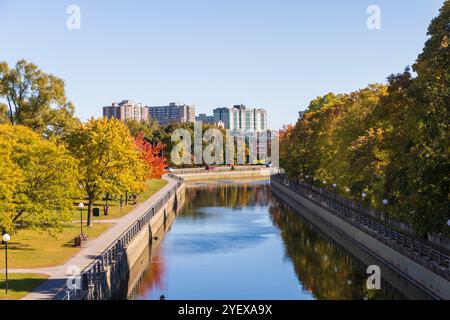 Rideau Canal in Ottawa, Canada during the autumn season lined with fall trees and residential buildings in background. Stock Photo