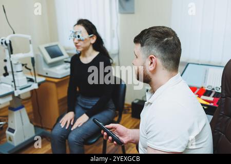 Eye examination of a young woman at an ophthalmologist's appointment using modern microscopes. Vision treatment using modern equipment Stock Photo