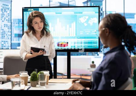 Group of business associates discussing project development plans, leveraging big data and advanced analytics to make informed decisions and enhance workflow efficiency. Multinational company. Stock Photo
