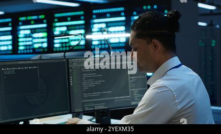 System administrator in data center maintaining accurate paperwork of hardware, generating reports. IT expert in high tech server farm doing workplace disaster recovery planning, camera A Stock Photo
