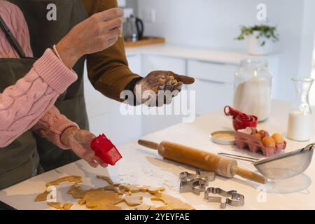 Christmas time, multiracial couple baking holiday cookies in cozy kitchen, at home Stock Photo