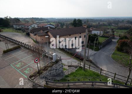 Parking lot of Fagagna (Pordenone) from above, with two electrical car charging stations, actually empty, many houses and the far hills Stock Photo