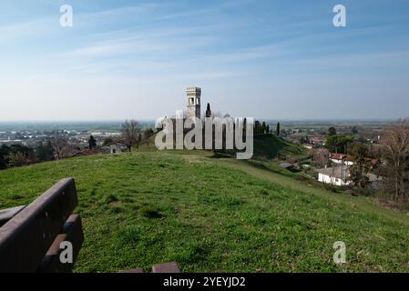 View of the castle of Fagagna in Friuli (Italy) from the green hilltop sit on a wooden bench in a summer day, the city in the background Stock Photo