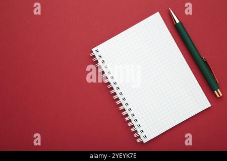 Notebooks and pen on red background, top view Stock Photo