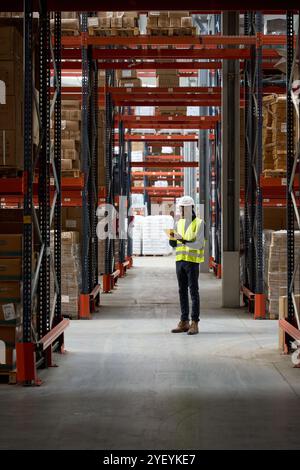 Warehouse worker using digital tablet checking inventory in logistics center Stock Photo