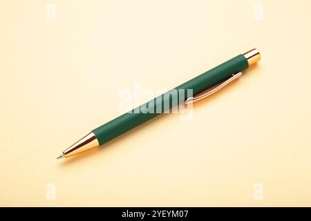 New stylish green pen on beige background. Stock Photo