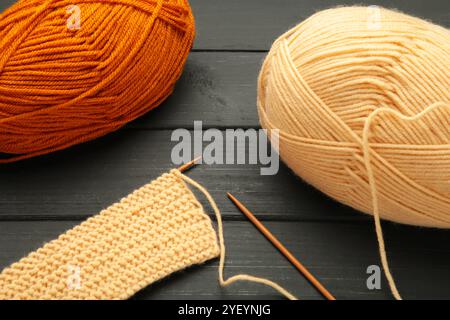 Different yarns, knitting needles on black background. Top view Stock Photo