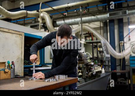 Metalworker operating cnc machine in manufacturing plant Stock Photo