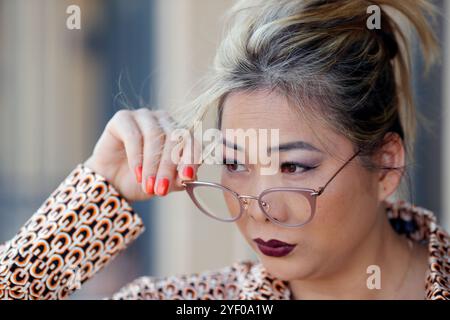 Young pretty woman with glasses on the tip of her nose. Stock Photo