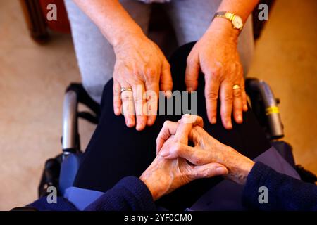 Retirment home. Close up of care assistants hand reassuring senior woman. Stock Photo