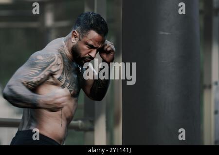Punch. Portrait of muscular sport man. Fists fight. Mans fight, punches. Kicks up. In the outdoor boxing arena. Man ready for boxings challenge. Man Stock Photo