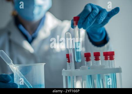 A dedicated scientist is meticulously conducting an experiment using various test tubes in a wellequipped laboratory setting, showcasing the process Stock Photo
