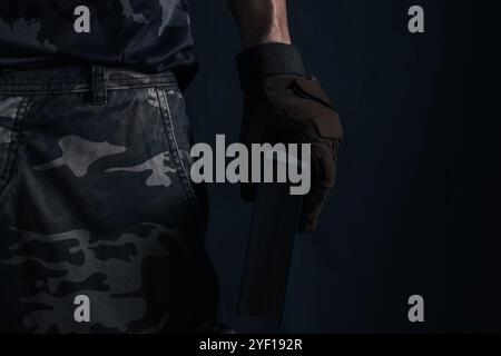 Closeup of soldiers hand with closed book on black background Stock Photo