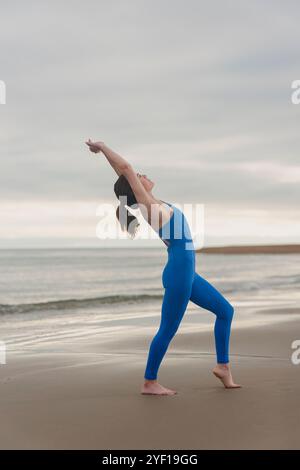 sporty woman doing a backbend yoga stretching exercise outdoors at the beach Stock Photo