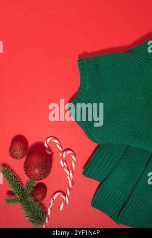 Turquoise green retro sweater wool background and Christmas decorations on red background top view Stock Photo