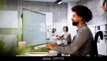 African American Coder Using Computer At Desk. Web Developer Stock Photo