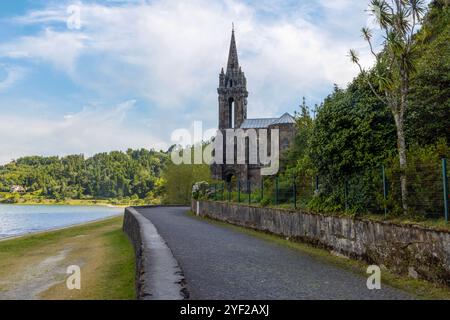 Nestled on the edge of the serene Furnas Lake on the Sao Miguel Island, the striking neo-Gothic Capela de Nossa Senhora das Vitórias is a testament to Stock Photo