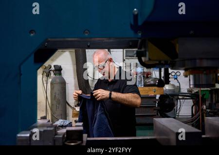 Metalworker taking notes of custom mechanical parts in metallurgy fabric Stock Photo