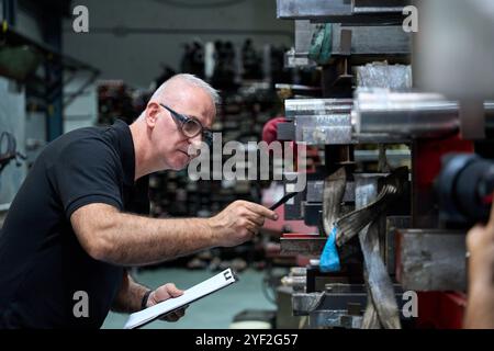 Metalworker operating cnc machine in factory workshop Stock Photo