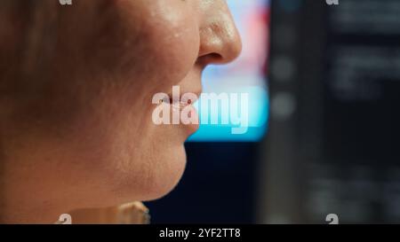 Extreme closer up shot of happy computer engineer satisfied after futureproofing company network from system failures. Smiling IT worker pleased after managing to increase data security, camera A Stock Photo