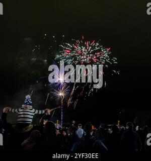 Crowds watching the Bicester Round Table 2024 annual fireworks display in Pingle Field, Bicester, Oxfordshire. Stock Photo