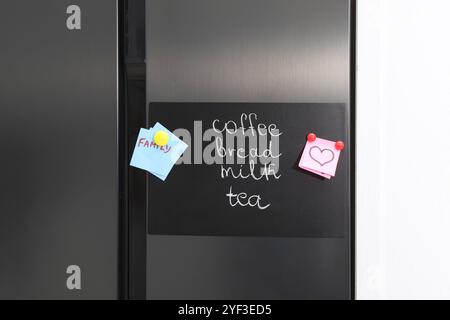 Magnetic board with shopping list and notes on refrigerator Stock Photo