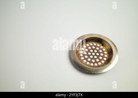 Metal drain cover with circular perforations on a clean surface Stock Photo