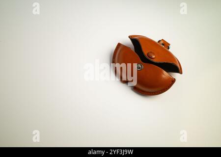 Small brown leather coin pouch with snap closure placed on a surface Stock Photo
