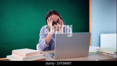 Bored Girl In Classroom Using Computer Technology. Laptop In Education Stock Photo