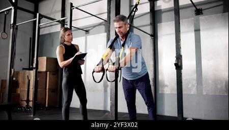 Sport Exercise In Gym. Fitness Athlete Doing Suspension Training Workout Stock Photo