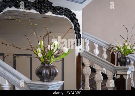 Simple spring flower arrangement of white tulips and blossoming branches. Stock Photo
