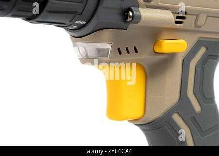Yellow button for starting and stopping wireless screwdriver on white background in closeup Stock Photo
