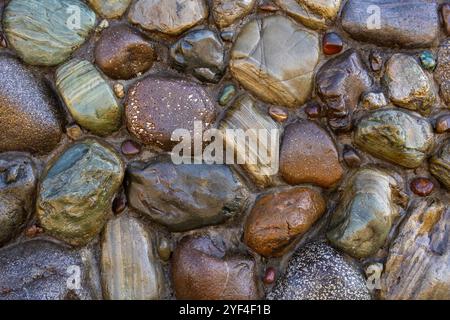 Cobblestone creative background texture. Smooth stones of different sizes, shapes and colours. Stock Photo