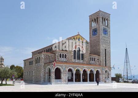 Stone church with bell tower and flags on a sunny square under a blue sky, Church of St Constantine and Helen, Volos, Pagasitic Gulf, Thessaly region Stock Photo