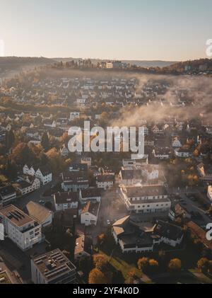 View over a town with autumn hills and fog in the air, Nagold, Black Forest, Germany, Europe Stock Photo