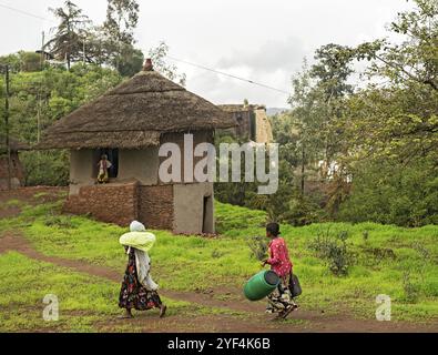 Villagers return to their traditional two-storey round village house with internal stairs and thatched roofs, Lalibela, Ethiopia, Africa Stock Photo