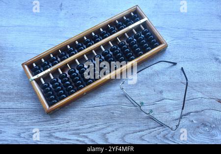 wooden abacus old Chinese tool for calcuated and eyeglass arraning on table Stock Photo