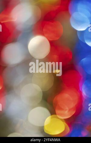 Defocused glowing lights, colorful abstract blurry bokeh background, vivid motion blur texture. Out of focus shining lens flare photo effect. Bright C Stock Photo