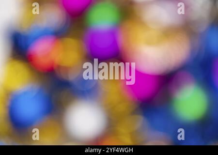 Defocused glowing Xmas balls holiday decorations, abstract blurry bokeh background effect. Out of focus colorful Happy New Year lights celebration tex Stock Photo