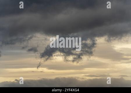 Amazing storm clouds in dusk sky during rainy weather. Dramatic view of natural cloudiness weather background. Motion blur, soft focus cloudscape back Stock Photo