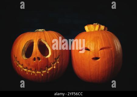 Two funny Halloween Pumpkins on dark background. Stock Photo