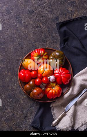 The harvest of assorted tomatoes. Colorful organic tomatoes on a large dish. Tomatoes different varieties. Top view Stock Photo