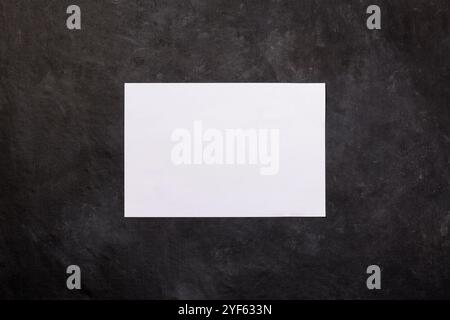 Blank white paper on dark background with copy space for text for your congratulations and messages, flat lay, top view Stock Photo
