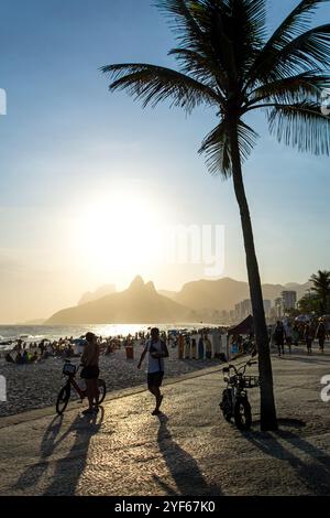 People walking on the promenade of Ipanema Beach in Rio de Janeiro in Brazil at sunset Stock Photo